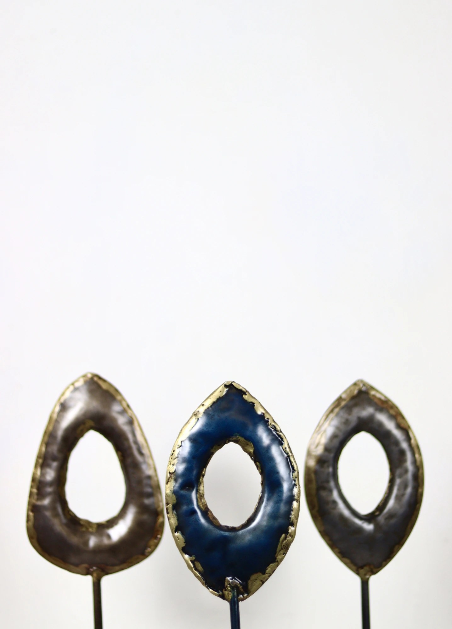 Cle and Co — three ring sculptures on stands